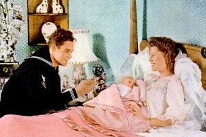 When Baby Boomers were babies: Happy couple visiting sick baby in bedroom, vintage family scene from mid-20th century.