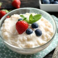 Creamy rice pudding in a bowl with blueberries and strawberry