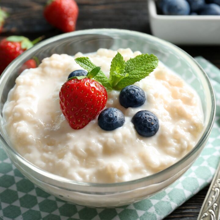 Creamy rice pudding in a bowl with blueberries and strawberry