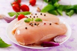 Raw chicken prepared for baking in a plate