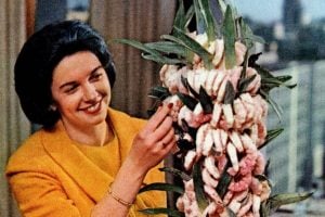 Woman with a vintage shrimp appetizer tree in 1965
